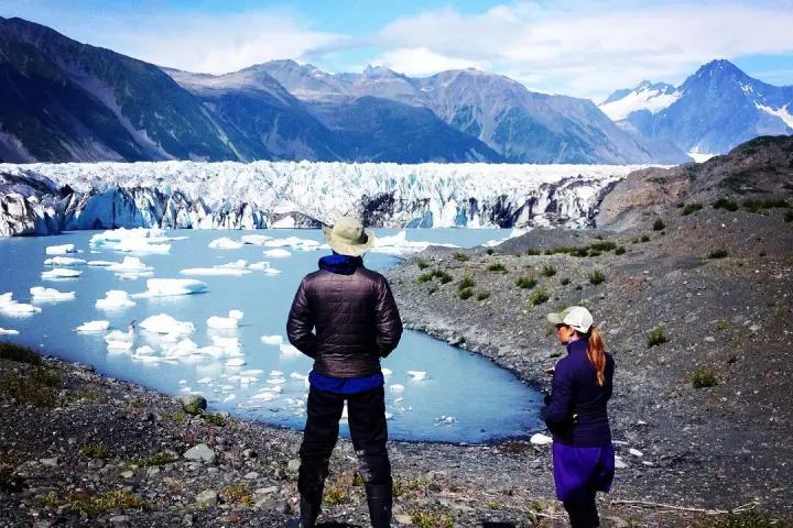 a group of people standing on top of a snow covered mountain