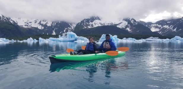 a small boat in a body of water with a mountain in the snow