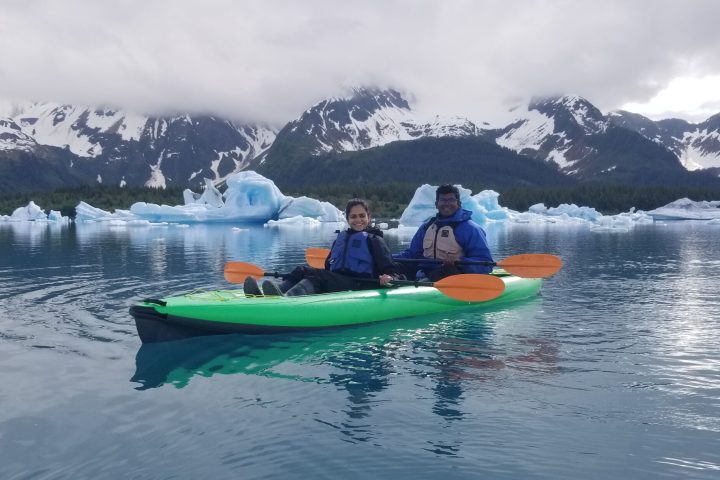 a small boat in a body of water with a mountain in the snow