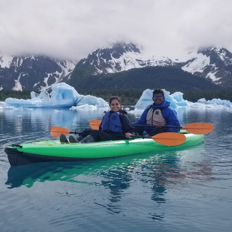 a small boat in a body of water with a mountain in the snow