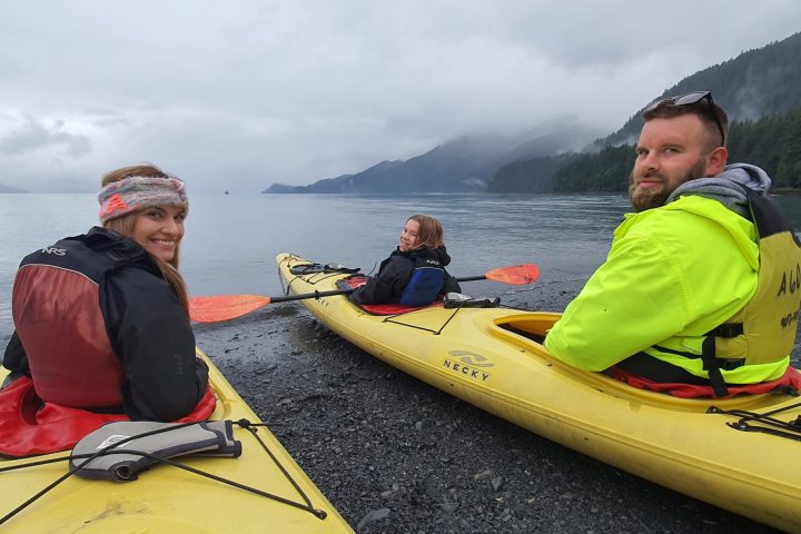 a young boy sitting next to a body of water