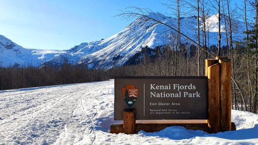 a sign on the side of a snow covered mountain