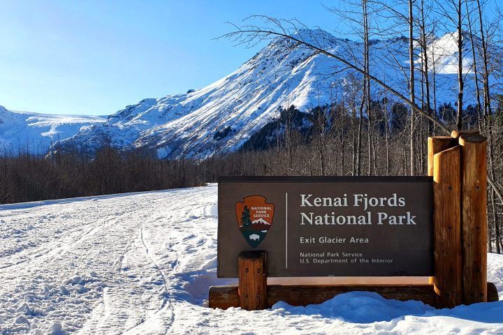 a sign on the side of a snow covered mountain