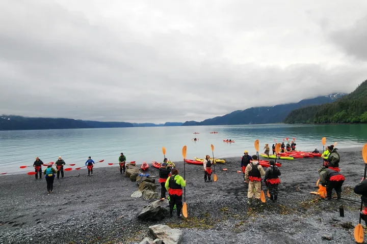 a group of people standing next to a body of water