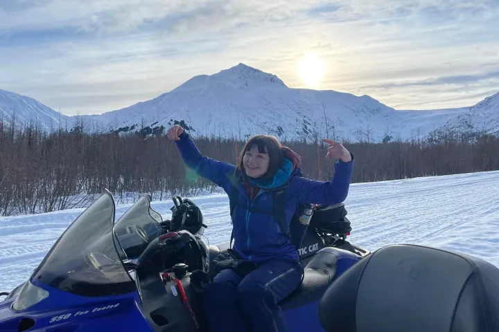 a person sitting on top of a snow covered mountain