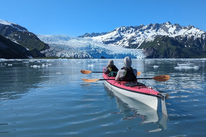 a group of people riding on the back of a boat in the water