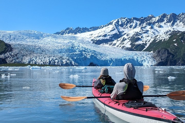 a man riding a surfboard on top of a snow covered mountain