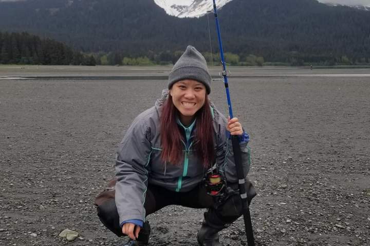a man holding a fish on a mountain