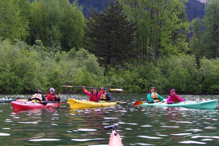 a group of people rowing a boat in the water