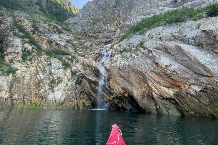a boat traveling along a river next to a body of water