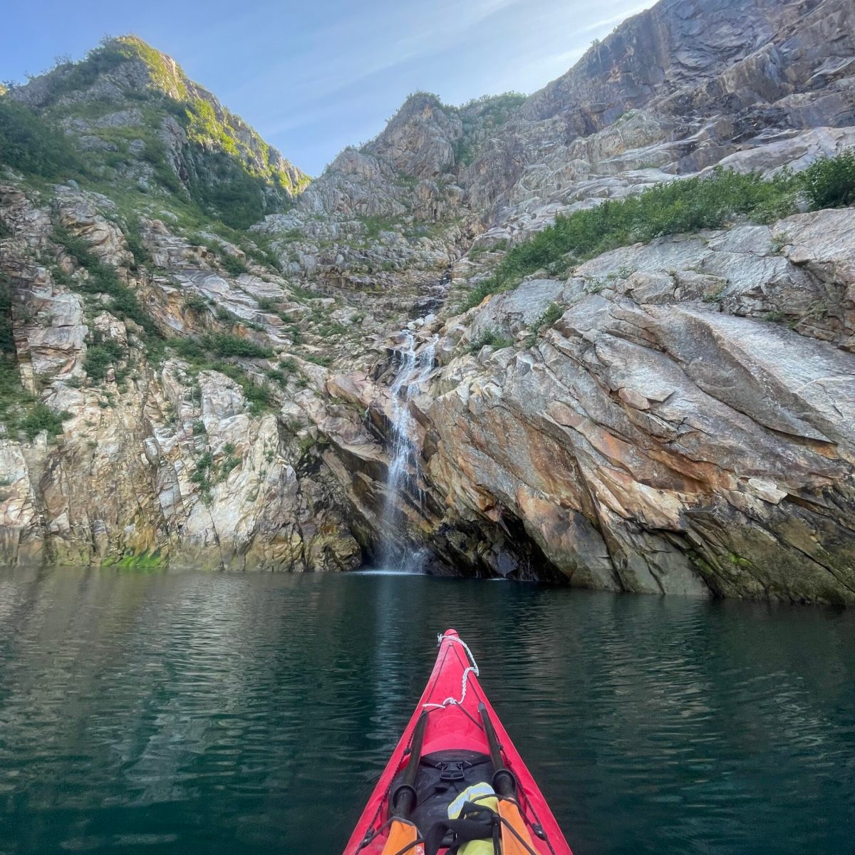 a boat traveling along a river next to a body of water