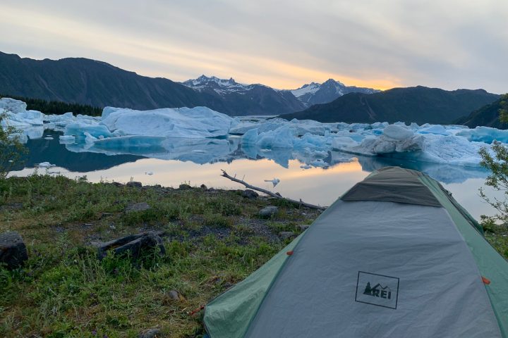 a tent on the side of a snow covered mountain