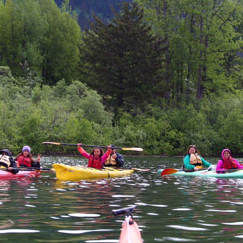 a group of people rowing a boat in the water