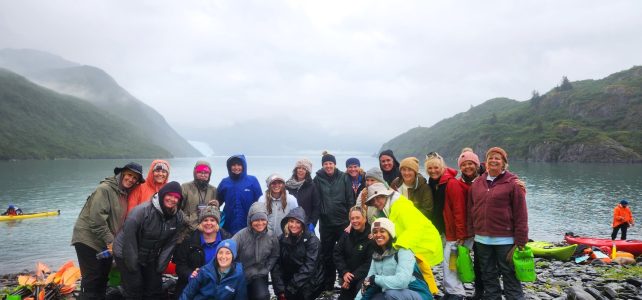 a group of people posing in front of a mountain