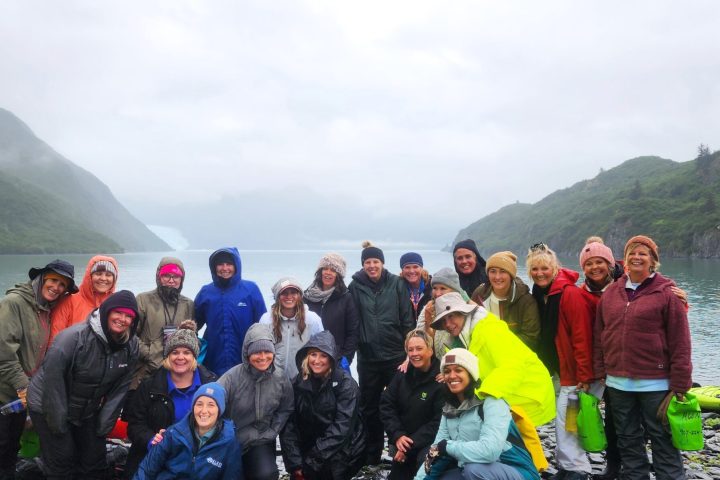 a group of people posing in front of a mountain