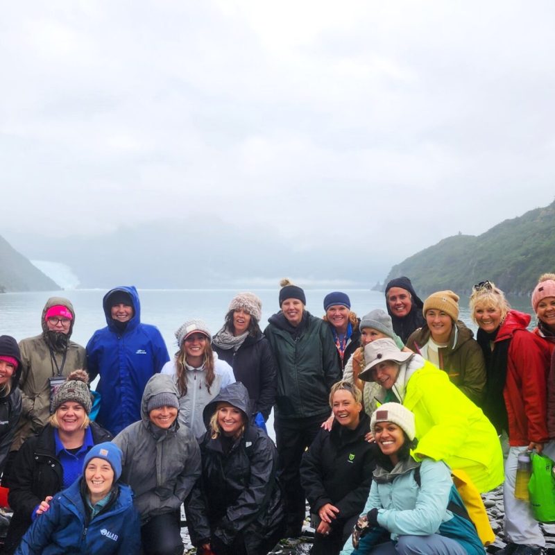 a group of people posing in front of a mountain