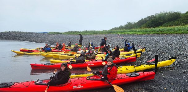 a group of people sitting on a raft in a body of water