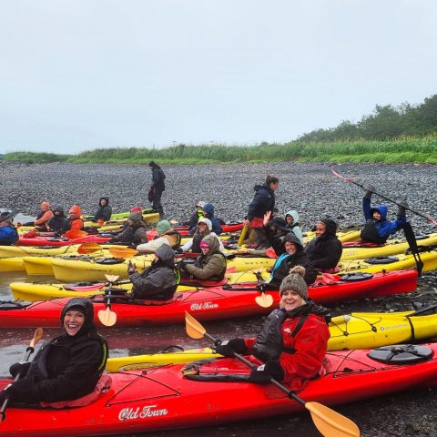 a group of people sitting on a raft in a body of water