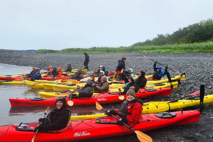a group of people sitting on a raft in a body of water