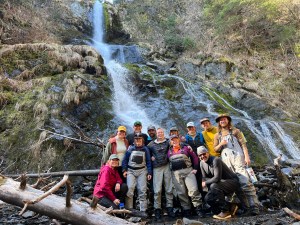 a group of people standing next to a waterfall