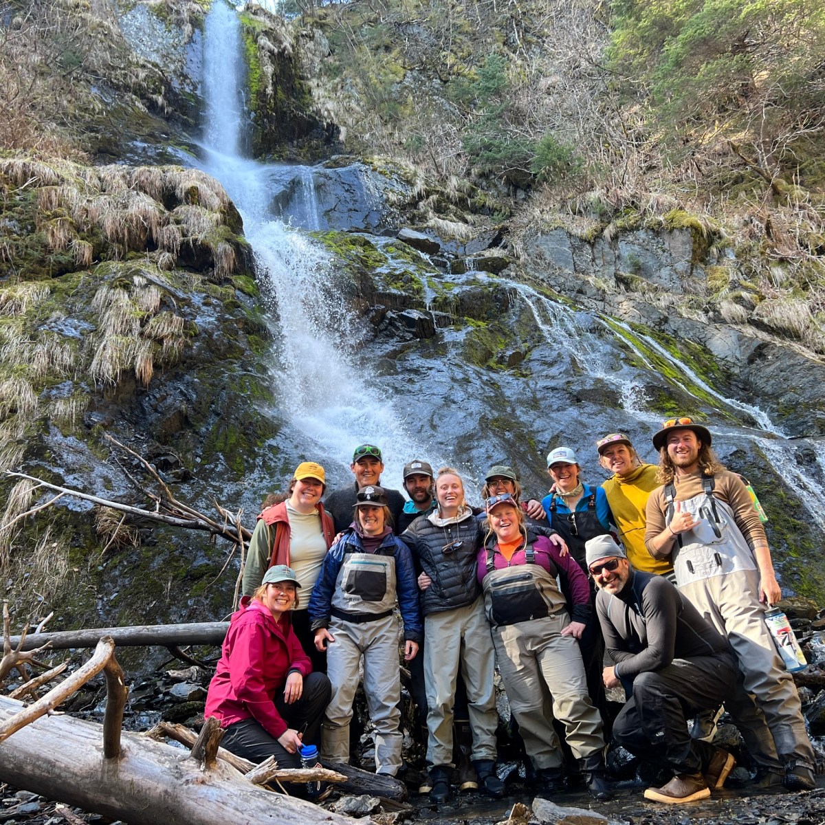 a group of people standing next to a waterfall