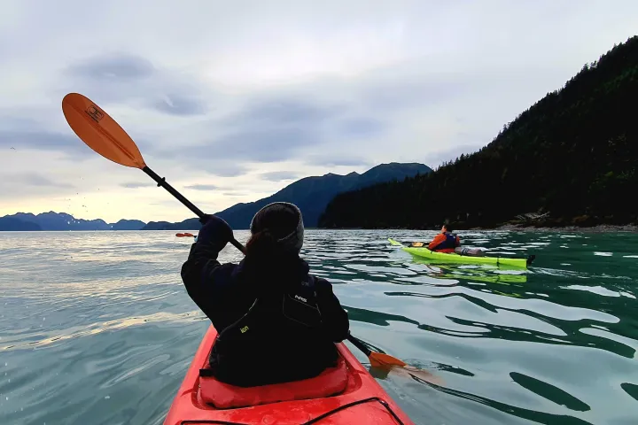 a person standing next to a body of water