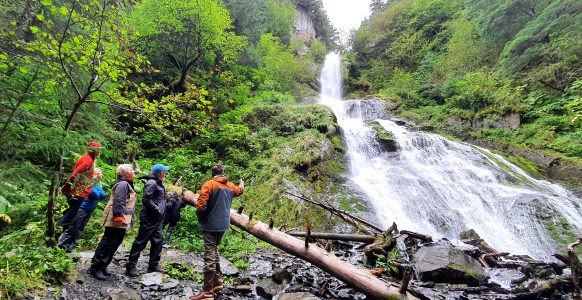 a man standing next to a waterfall