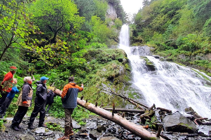 a man standing next to a waterfall