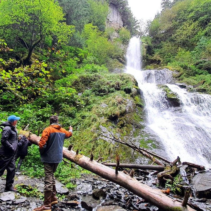 a man standing next to a waterfall