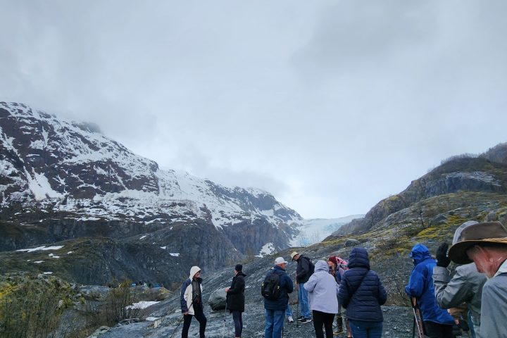 a group of people standing on top of a snow covered mountain