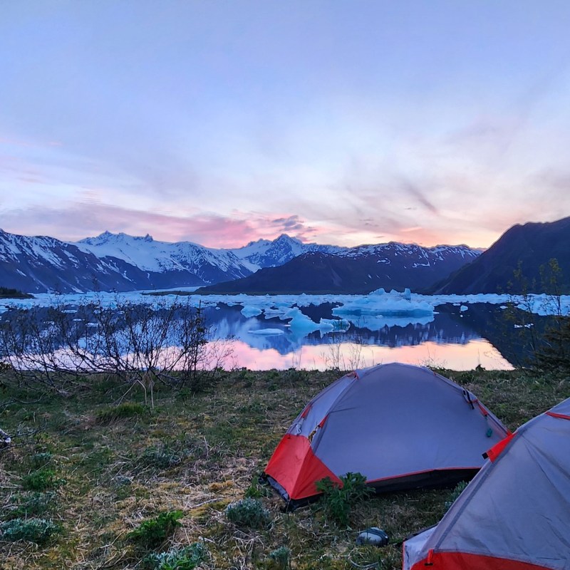 a tent in a field with a mountain in the background